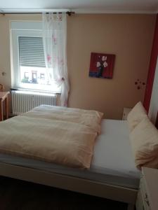 a bedroom with a white bed with a window at Hotel Zur Brücke in Minheim