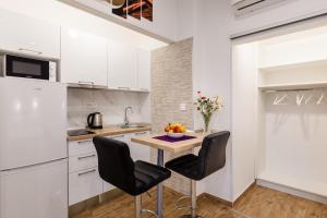 cocina con mesa pequeña y sillas en una habitación en Apartments Martha, en Dubrovnik