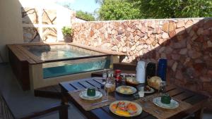 a table with food on it with a swimming pool at Pousada O Refúgio in Jericoacoara