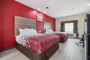 Habitación de hotel con 2 camas y pared roja en Econo Lodge Inn & Suites Humble FM1960 - IAH Airport en Humble