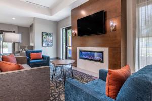 sala de estar con chimenea y TV en Comfort Suites Gainesville Near University, en Gainesville