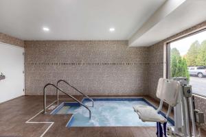 a hot tub in a room with a window at Clarion Pointe Racine - Mount Pleasant in Racine