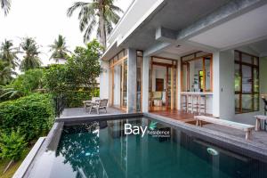 a villa with a swimming pool and a house at Bay Villas Koh Phangan in Salad Beach