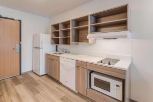 uma cozinha com um frigorífico branco e um lavatório em WoodSpring Suites Tri-Cities Richland em Richland