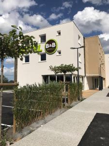 a building with a sign on the side of it at B&B HOTEL Ouistreham in Ouistreham