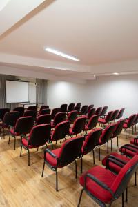 an empty room with red chairs and a whiteboard at Valerim Florianópolis in Florianópolis