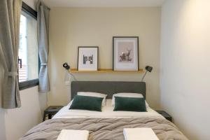 una camera con un letto con due cuscini verdi di NOCNOC - Le Donatello a Lione