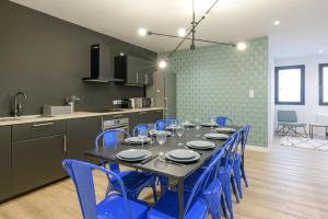una sala da pranzo con tavolo e sedie blu di NOCNOC - Le Donatello a Lione