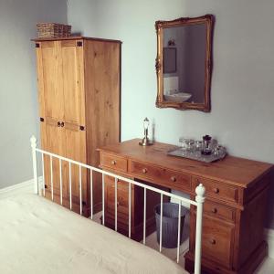 una camera da letto con cassettiera in legno e specchio di Kings Arms Hotel a Ulverston