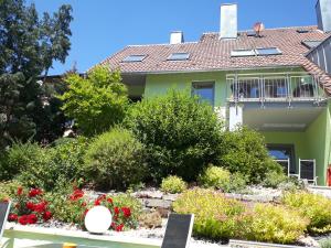 uma casa com um jardim em frente em Ferienwohnung Pension am Weinberg em Mainstockheim