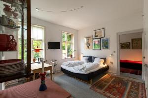 a bedroom with a bed and a desk and a tv at To sammenhængende værelser med udgang til have in Ribe