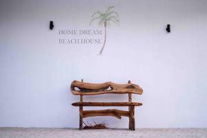a wooden chair in front of a wall with a house dream reach house at Home Beach Dream House in Carvalhal