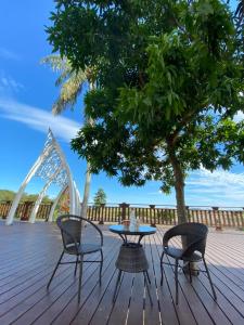 einen Tisch und Stühle auf einer Terrasse mit einem Baum in der Unterkunft Starry Night in Taitung