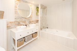 a bathroom with two sinks and a tub and a mirror at Le Grenier du Photographe in Kaysersberg +28 photos