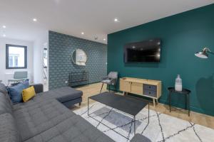 ein Wohnzimmer mit einem Sofa und einer blauen Wand in der Unterkunft NOCNOC - Le Michelangelo in Lyon