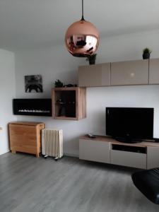 a living room with a flat screen tv and a couch at Apartment Green Garden in Middelkerke