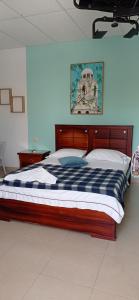 a bedroom with a bed with a blue and white comforter at Hotel Los Estoraques in Aguachica