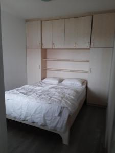 a white bed in a room with white cabinets at Apartment Green Garden in Middelkerke
