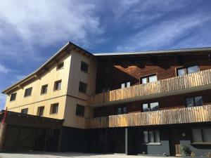 an apartment building with a wooden fence around it at Alpha Apartment in Schröcken