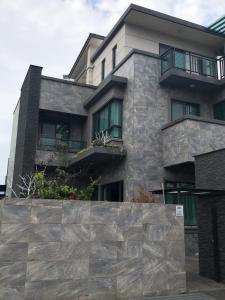 un edificio con una pared de piedra delante de él en 上雅居, en Sanxing