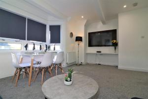 伦弗鲁Jess View的配有桌椅和电视的客厅