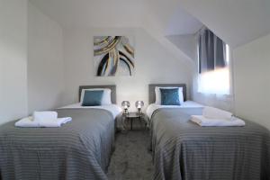 una camera con due letti con asciugamani di Jess View a Renfrew