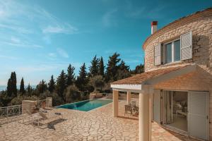 a stone house with a swimming pool and a patio at The Round House in Vlachopoulátika