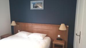 sypialnia z łóżkiem z 2 białymi poduszkami w obiekcie Hôtel De La Perdrix Rouge w Paryżu