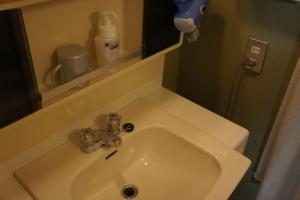 a white sink in a bathroom with a mirror at Sumiyoshiya in Kanazawa