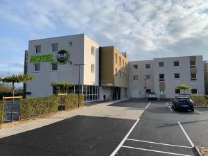 a car parked in a parking lot in front of a building at B&B HOTEL Ouistreham in Ouistreham