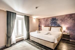 ローマにあるフォーヘッズ プライベート スイートのベッドルーム1室(壁に絵画が描かれた大型ベッド1台付)