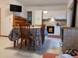 a kitchen with a table and chairs with a table cloth at Appartamenti Mosconi Mistica in Vermiglio