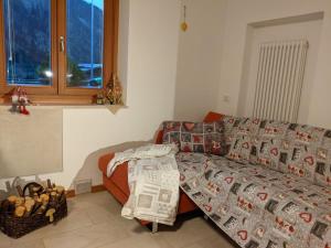uma sala de estar com um sofá e um cobertor em Appartamenti Mosconi Mistica em Vermiglio