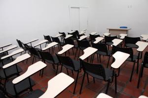 an empty room with desks and chairs in it at Hotel Vitoria - Itajaí in Itajaí