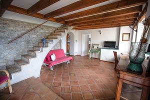 een woonkamer met een rode stoel en een trap bij Giacomazzi House BRI in Malcesine