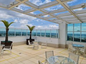 a large room with tables and chairs and palm trees at Flat Brasília - Setor Hoteleiro Norte in Brasilia