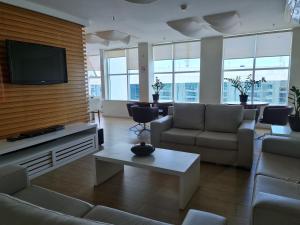 ein Wohnzimmer mit Sofas und einem Flachbild-TV in der Unterkunft Flat Brasília - Setor Hoteleiro Norte in Brasilia