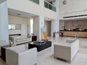 巴西利亞的住宿－Flat Brasília - Setor Hoteleiro Norte，大堂设有两把白色椅子和一张桌子