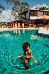 una mujer en el agua en una piscina en Hotel Solar do Imperador, en Porto Seguro