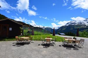 a group of tables and chairs with mountains in the background at Panoramagasthof Kristberg in Silbertal