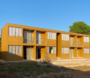 een oranje gebouw met balkons aan de zijkant bij Delú Residences in Alto Paraíso de Goiás