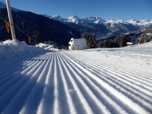 a snow covered slope with mountains in the background at Panoramagasthof Kristberg in Silbertal