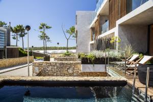 a house with a swimming pool next to a building at Areias do Seixo Villas in Santa Cruz