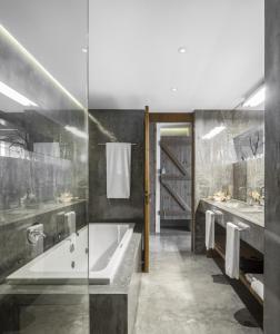 een badkamer met een bad en 2 wastafels bij Areias do Seixo Villas in Santa Cruz