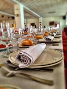 a long table with plates and forks and wine glasses at Hotel Heredero in Olivenza