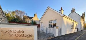 a house with a sign that reads duke coffee at Duke Cottage in Fochabers