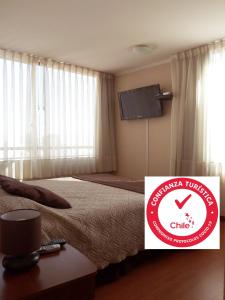 a hotel room with a bed and a sign that says china tourism clinic at Personal Aparts Bellas Artes in Santiago