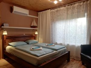 - une chambre avec un lit et 2 serviettes dans l'établissement Belloapartamento Ház Balatonkenese, Strand 800m, Jakuzzi, à Balatonkenese