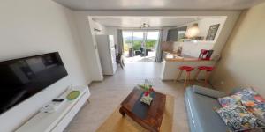 een woonkamer met een bank en een tafel en een keuken bij Résidence BelKay - Sur La Baie in Ducos