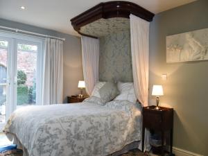 ein Schlafzimmer mit einem Himmelbett und einem Fenster in der Unterkunft Manor Farm Egerton in Malpas